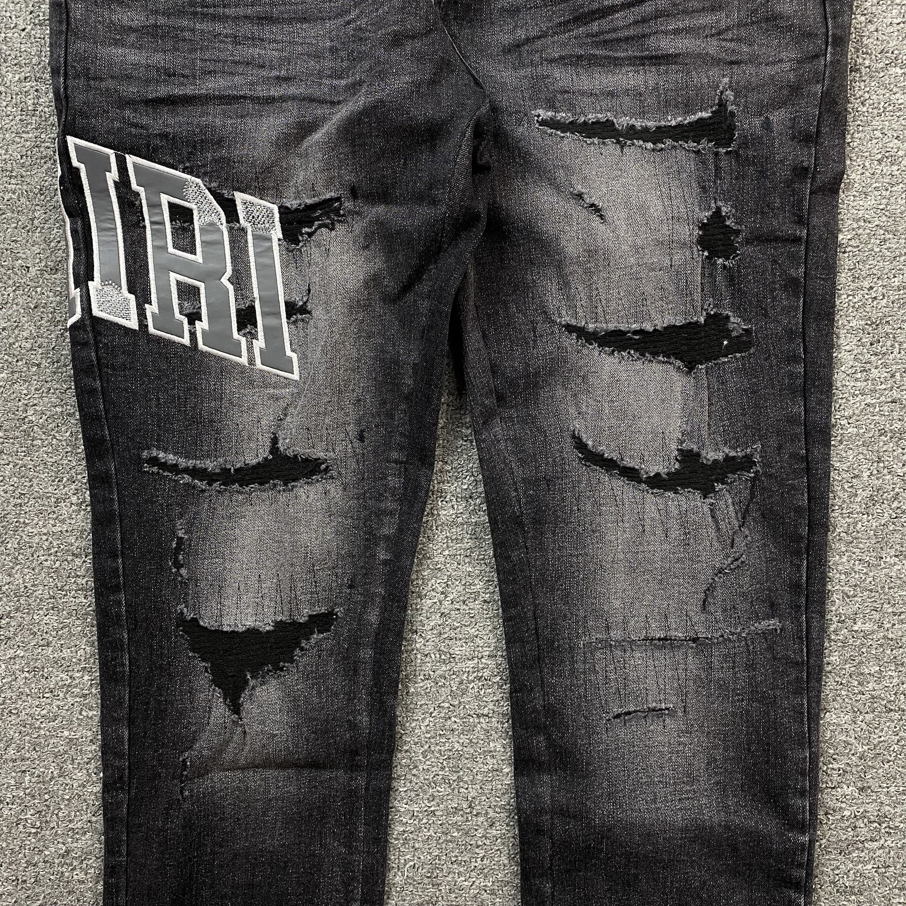 AMIRI VARSITY LOGO REPAIR JEANS